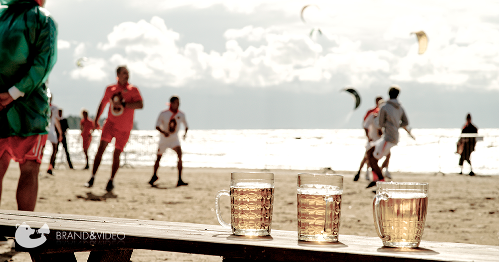 мужчины играют в футбол на переднем плане три кружки пива