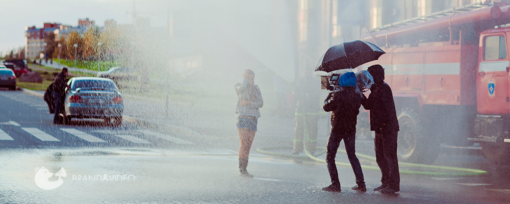 оператор с камерой снимает девушку под дождем