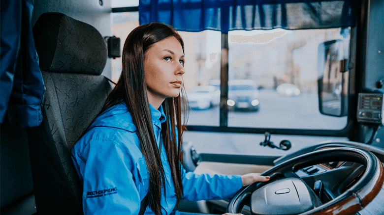 Водитель женщина управляет автобусом