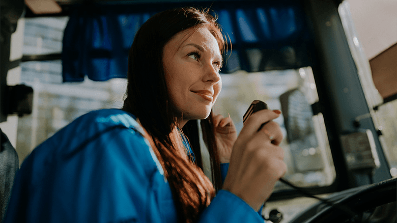 Девушка-водитель автобуса улыбается