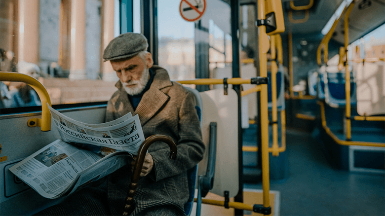 Дед читает газету в автобусе