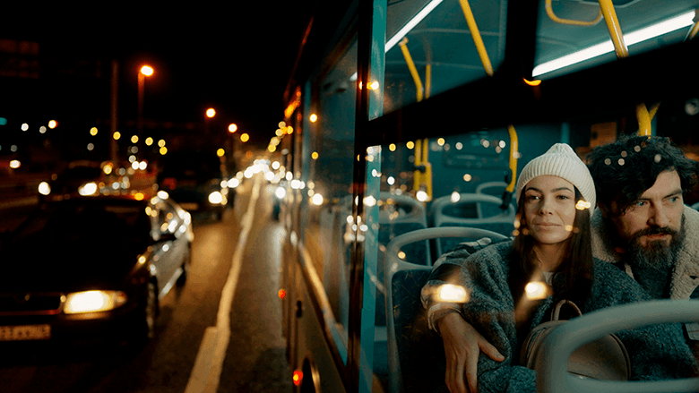 Влюблённая пара в автобусе, вид снаружи через стекло