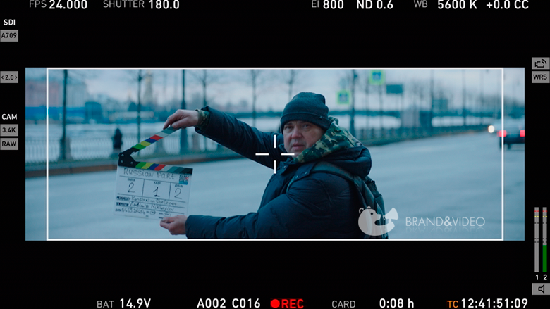 Мужчина с кинохлопушкой на фоне Санкт-Петербурга, вид из камеры