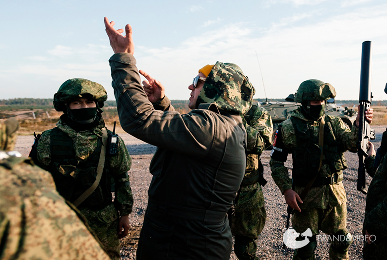 продюсер на съемках объясняет задачу военным